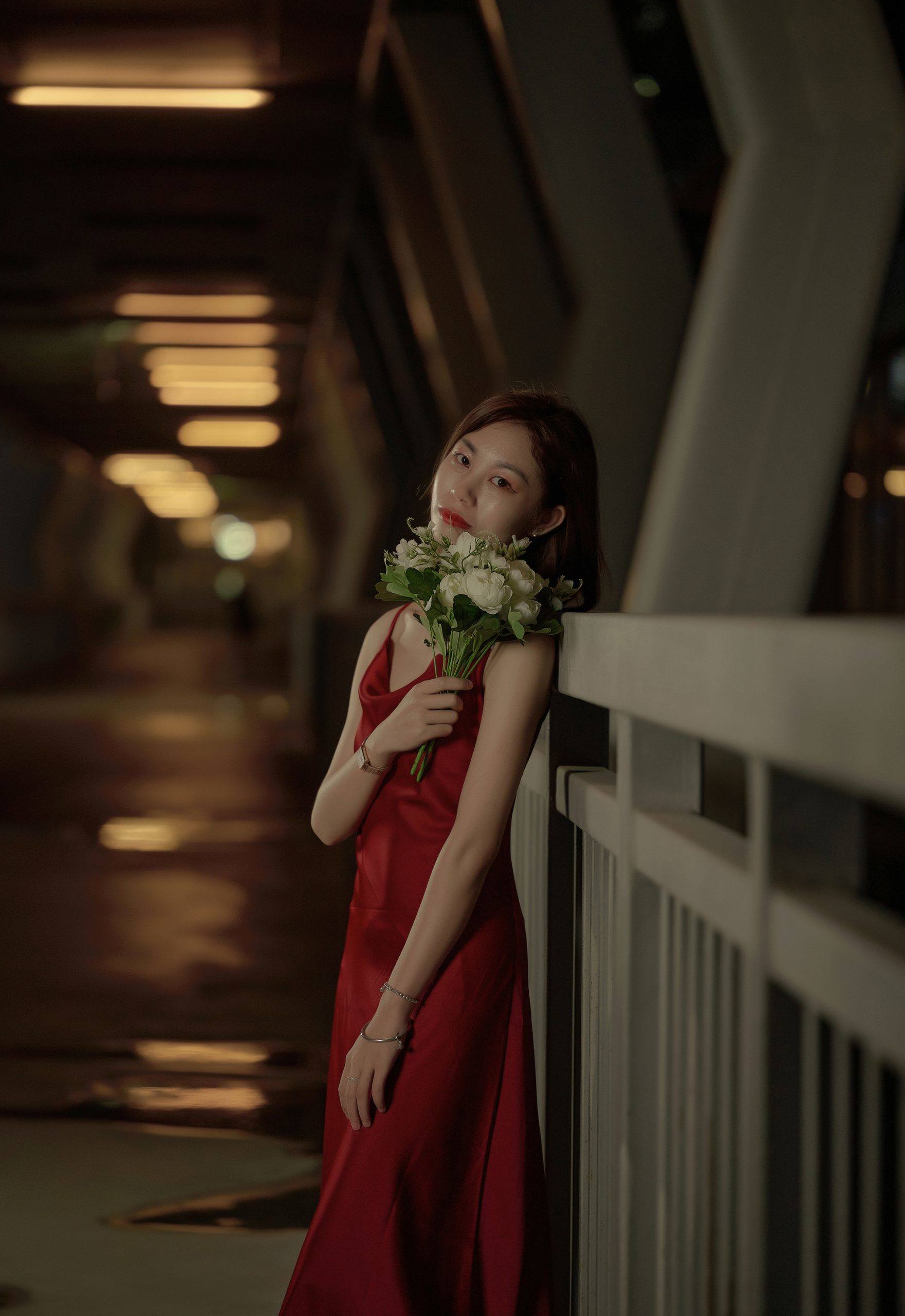 当夜幕降临，绚丽多彩的红色吊带裙穿梭在这座城市的心脏🌃。-摄之社